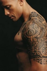 Dwayne “The Rock” Johnson proudly displays for his large, traditional Polynesian tattoo